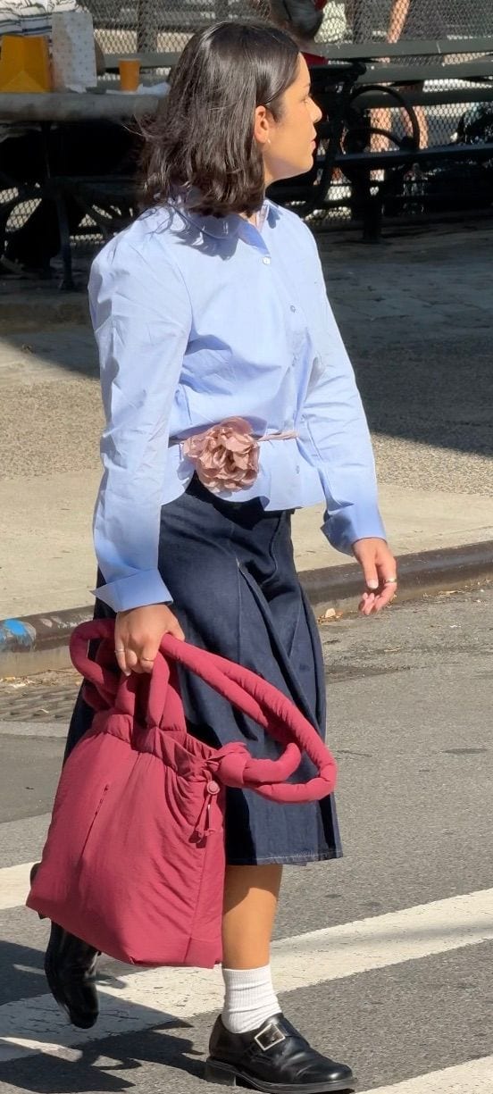 Light blue button-up shirt, denim midi skirt, dark red tote bag, and black buckled shoes.