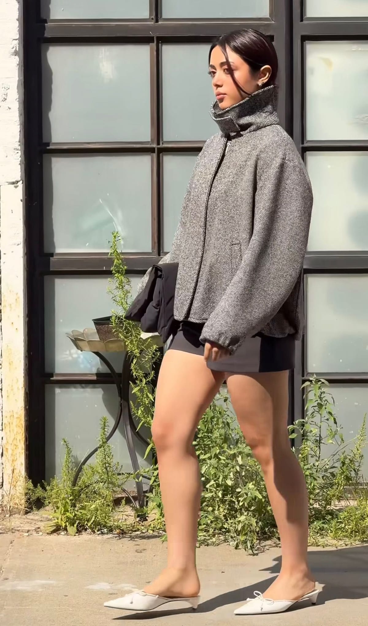 Grey tweed high-neck jacket, black mini skirt, and white bow mules.
