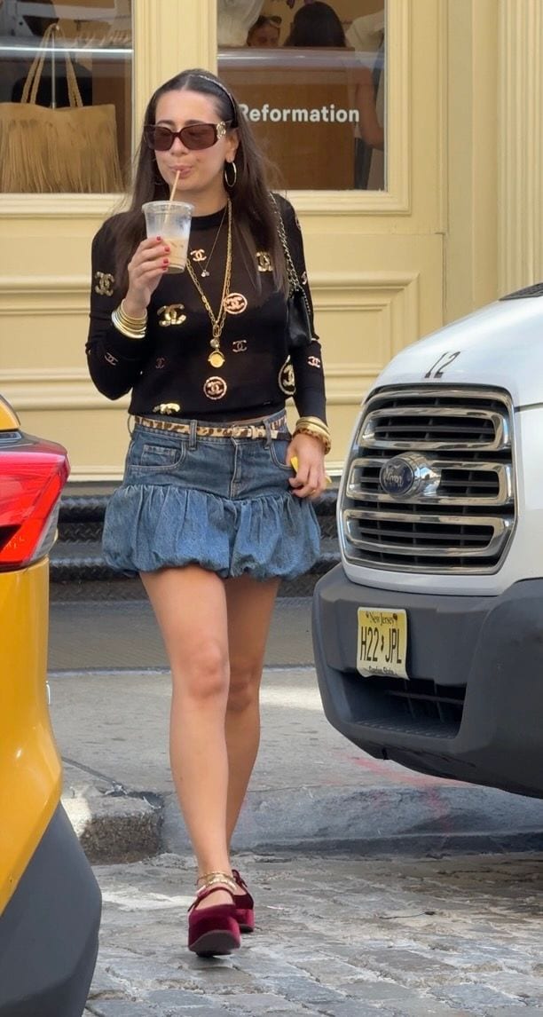 Black long-sleeve top with gold logos, denim bubble skirt, velvet platform Mary Janes.