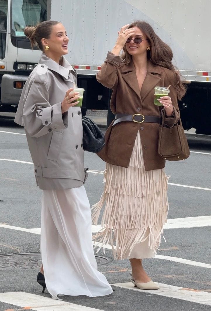 Grey trench coat over white maxi dress; brown suede jacket with fringe skirt.