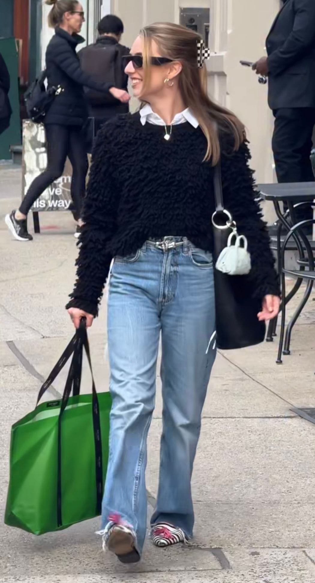 Black textured sweater over white shirt, light wash jeans, and zebra print shoes.