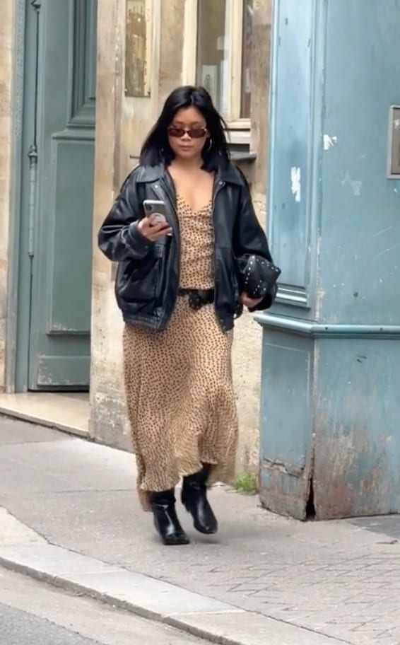 Black leather jacket over a leopard print maxi dress with black boots and sunglasses.