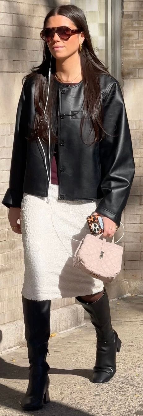 Black faux leather jacket, white sequin midi skirt, black knee-high boots, and pink quilted bag.
