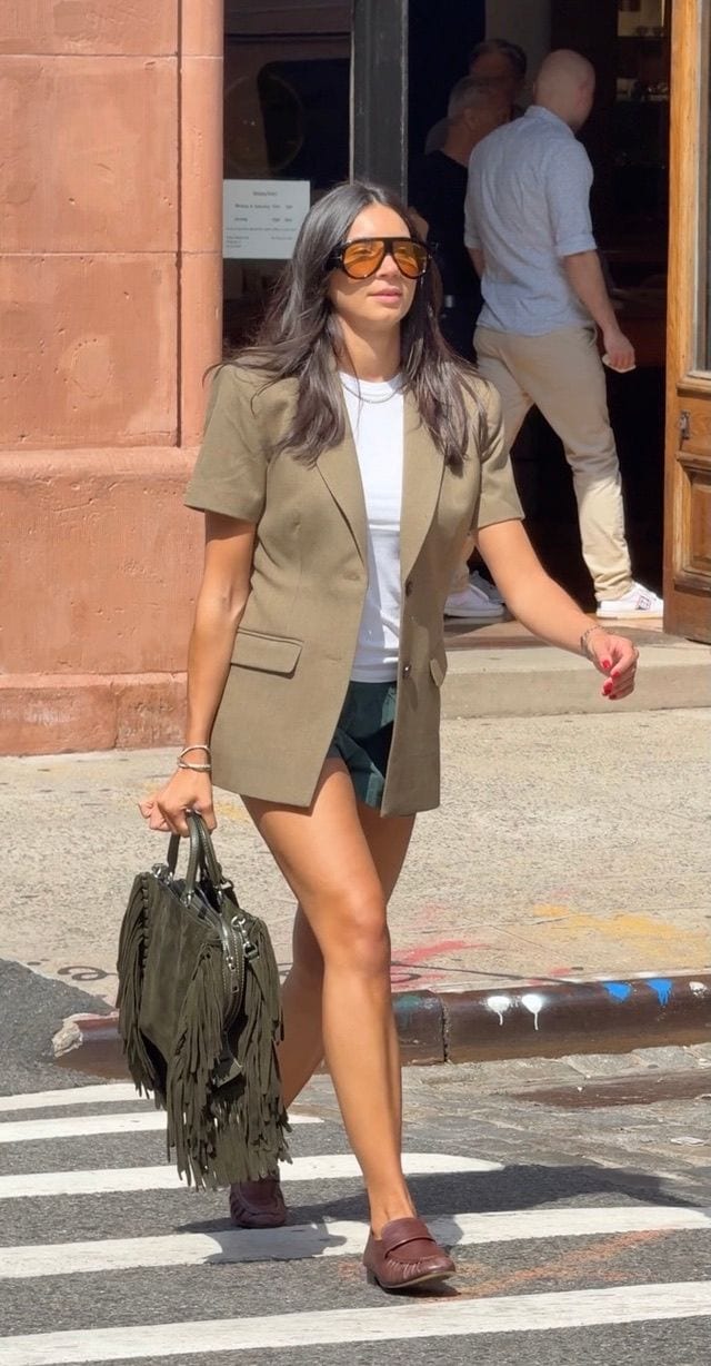 Olive short-sleeved blazer, white tee, green shorts, brown loafers, olive fringe bag, sunglasses.