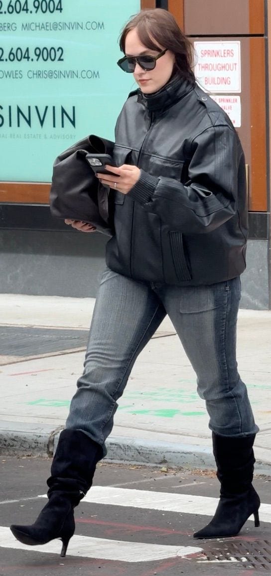 Black leather bomber jacket, gray jeans, black suede slouch boots, and sunglasses.
