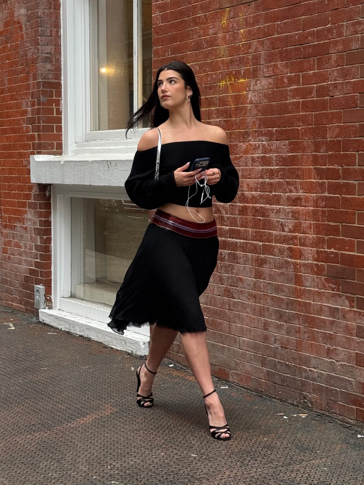 Black off-the-shoulder crop top, midi skirt with embellished waistband, and strappy heels.