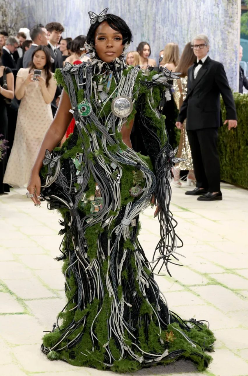 Black dress covered in green moss, computer wires, circuits, and silver butterflies.