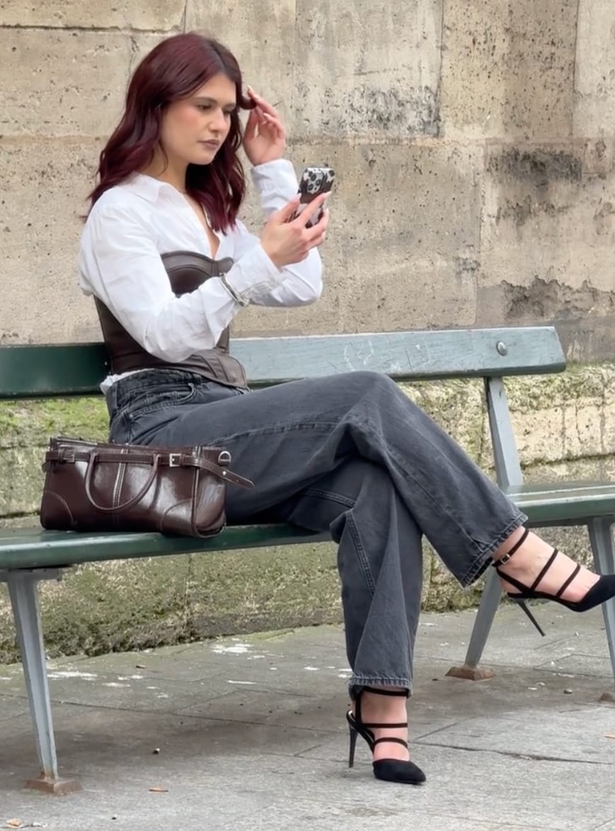 White shirt, brown corset top, black jeans, and black strap heels.