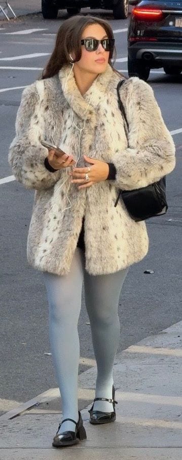 Faux fur coat with white and gray spots, light blue tights, black Mary Janes, and sunglasses.