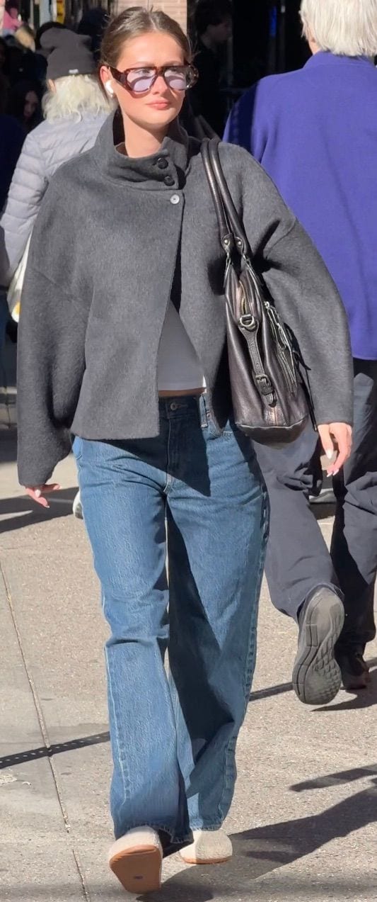 Gray collared jacket, white crop top, blue jeans, fluffy slippers, and tortoise sunglasses.