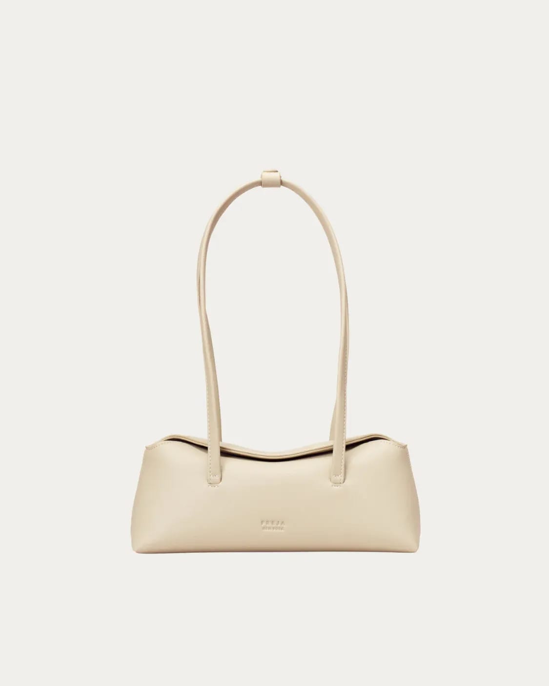 Cream elongated shoulder bag with two thin straps and "FREJA NEW YORK" embossed.