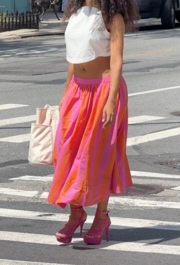 White crop top, pink and orange striped maxi skirt, and fuchsia platform heels.