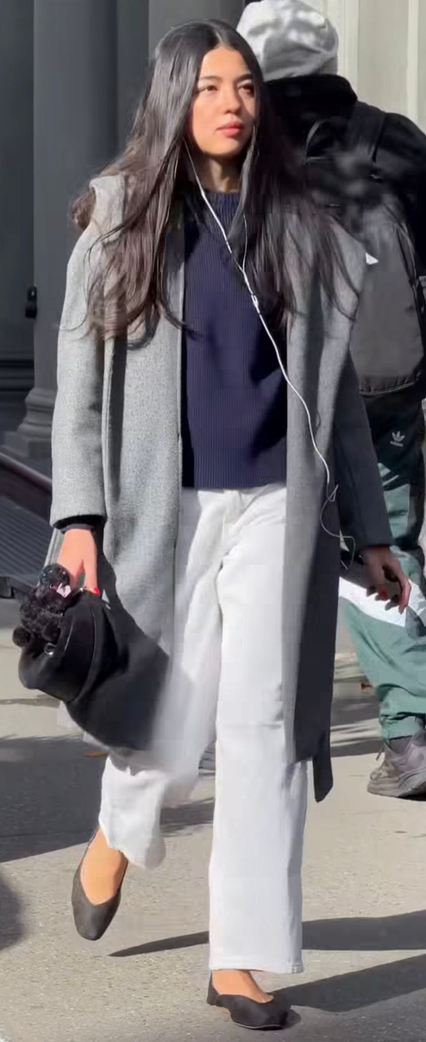 Grey coat over navy ribbed top, white wide-leg pants, black flats, and handbag.