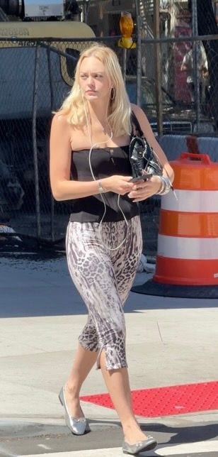 Black strapless top, animal print capris, silver flats, and black purse on street.