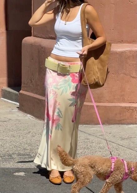 White tank top, floral maxi skirt, yellow belt, tan flats, and suede bag with dog.