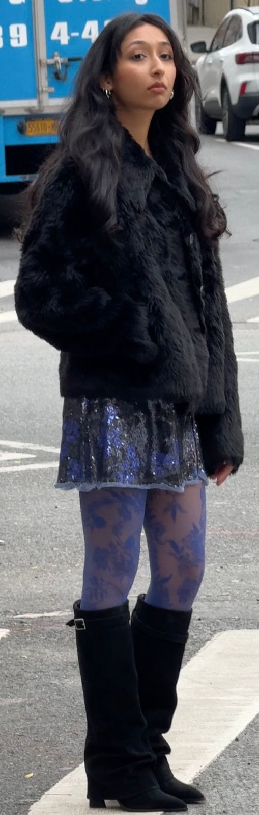 Black faux fur jacket, blue sequin mini skirt, floral blue tights, and black boots.