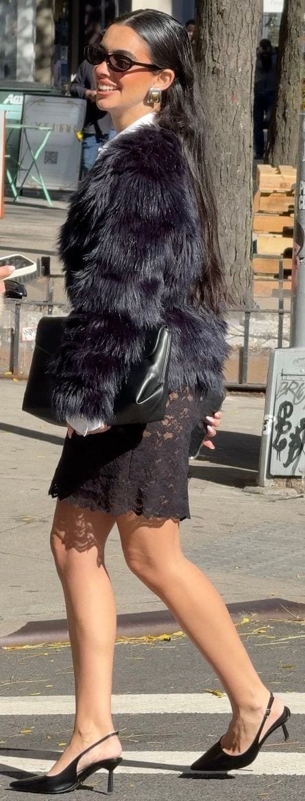 Black shaggy fur coat, black lace mini skirt, black slingback heels, and sunglasses.