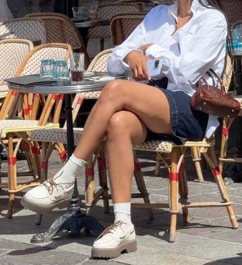 White oversized shirt, denim mini skirt, chunky white loafers, and brown croc bag.