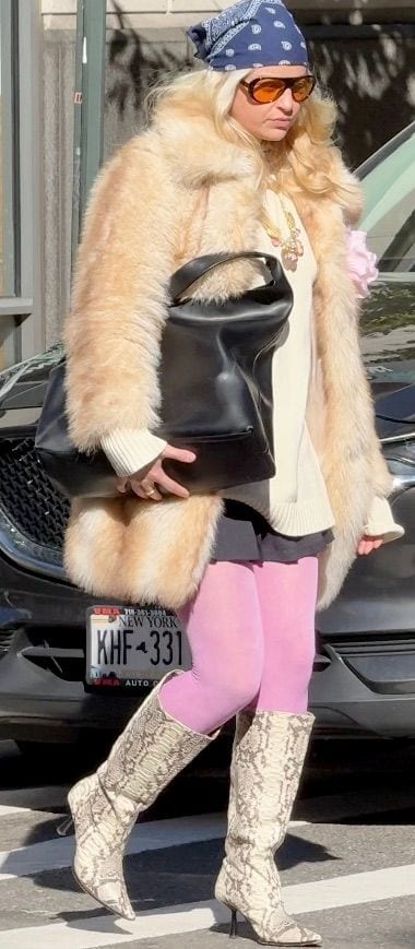 Blonde hair, blue bandana, orange sunglasses, light fur coat, pink tights, snakeskin boots.