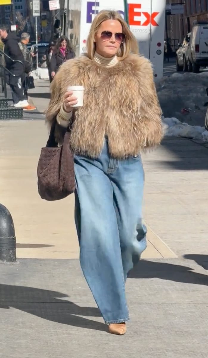 Light brown fur coat, white turtleneck, wide-leg jeans, brown woven bag, and sunglasses.