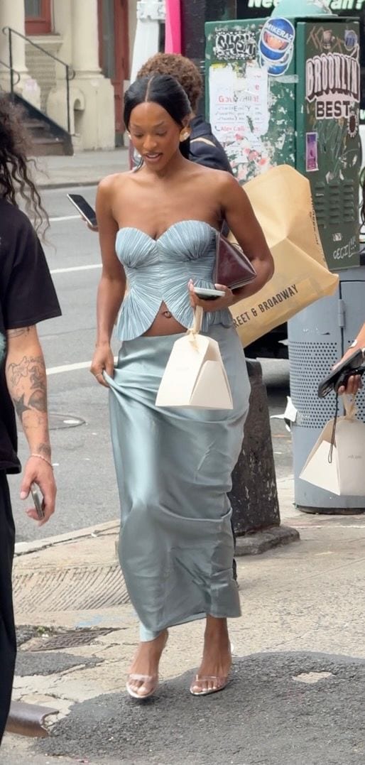 Light blue pleated strapless top and matching maxi skirt, clear heels, unique white bag.
