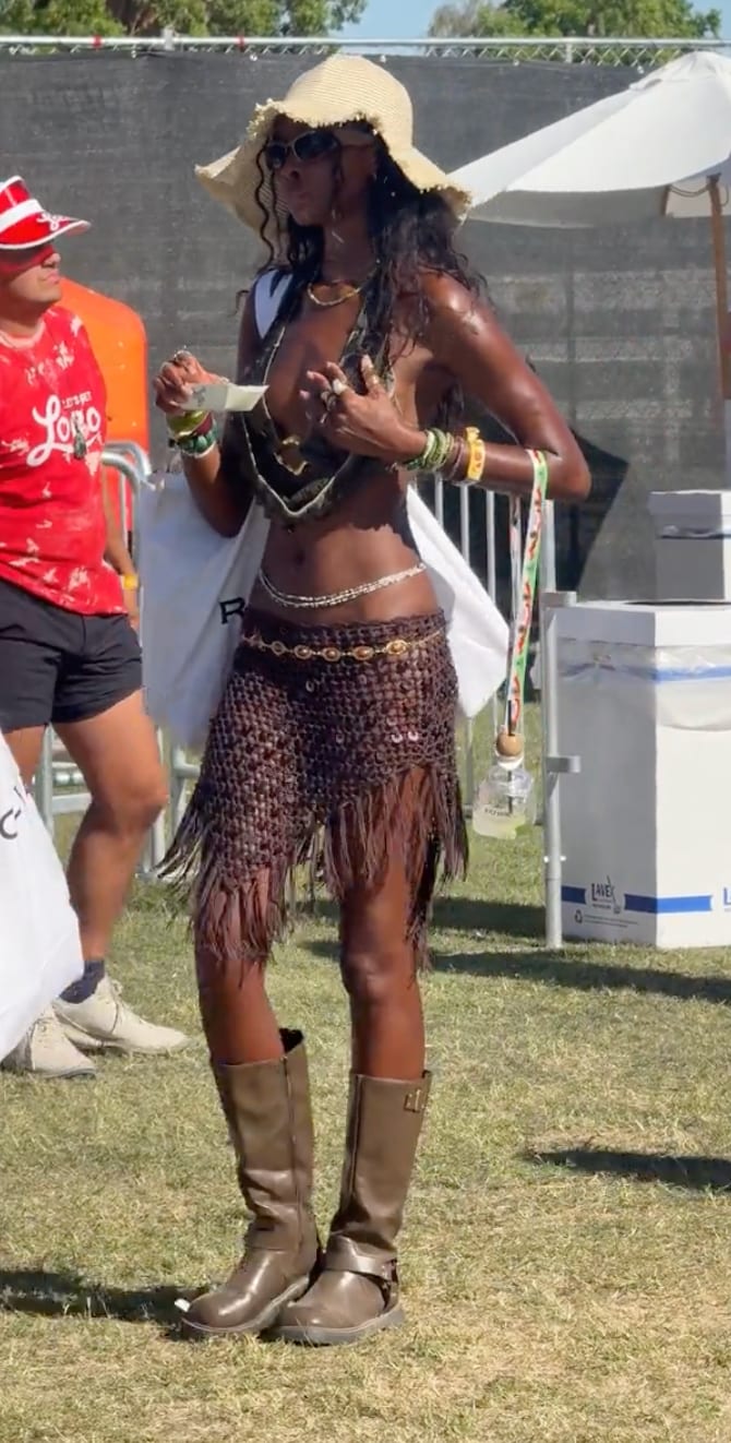Boho festival style featuring a raffia hat, brown crochet fringe skirt, and tall brown boots.