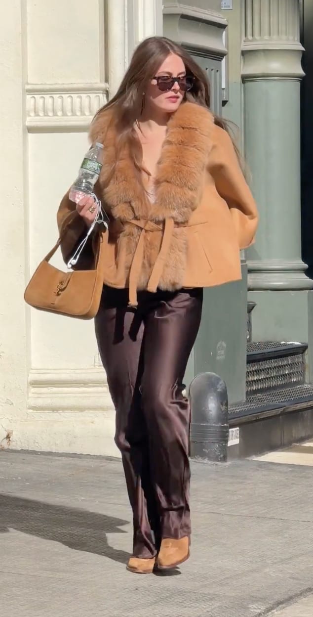 Tan faux fur collared jacket, brown satin pants, suede handbag, and sunglasses.