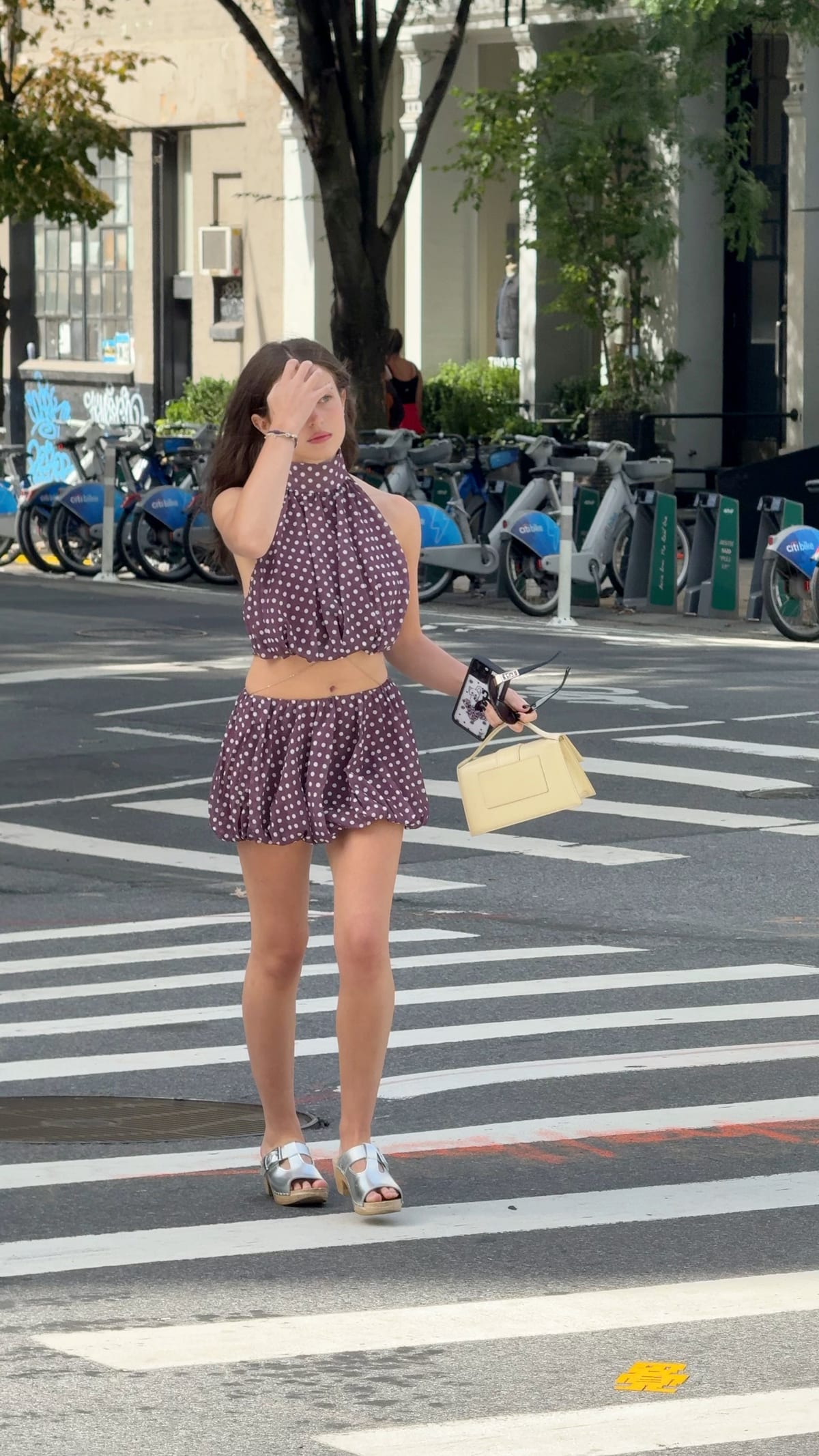 Purple polka dot halter crop top and bubble skirt with silver clogs and a yellow bag.