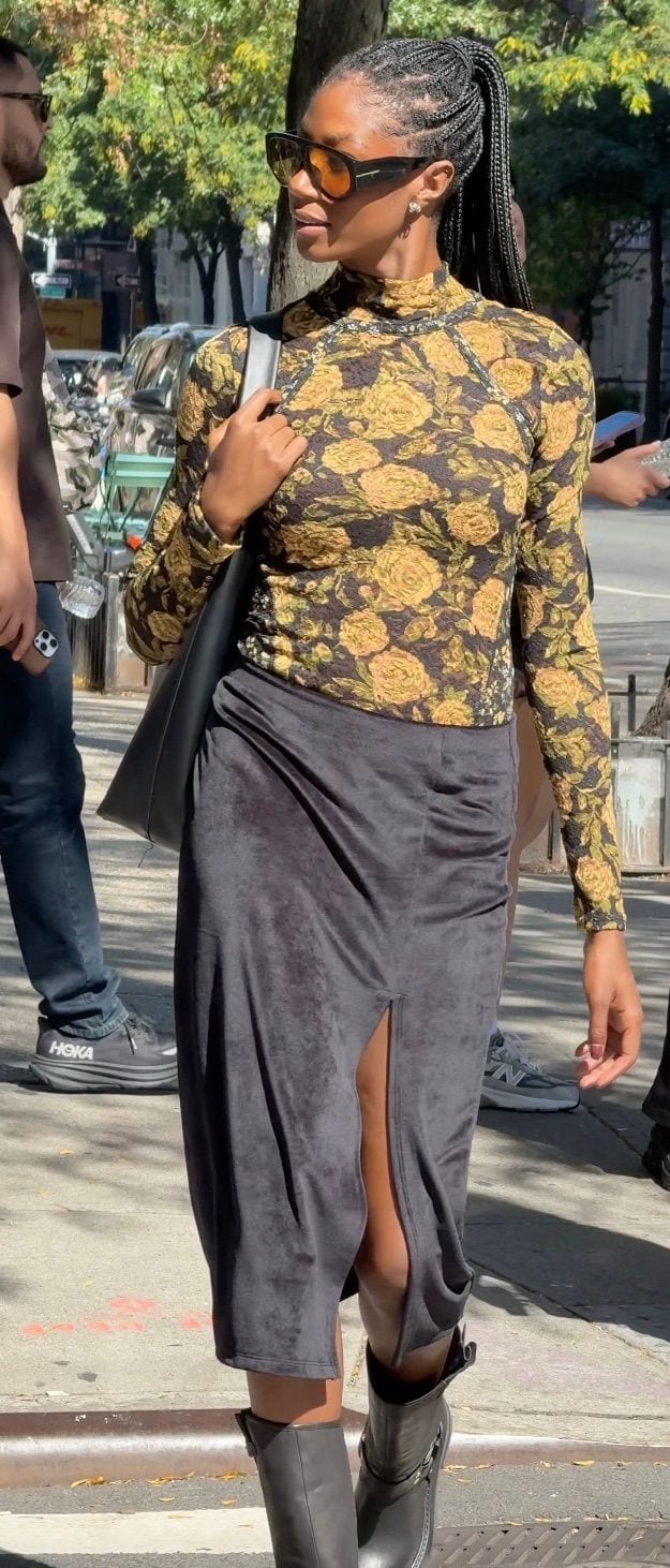Black mock neck top with yellow floral print, gray velvet skirt with a thigh-high slit, and black boots.
