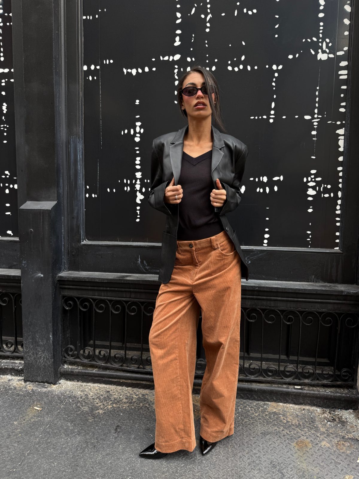 Black leather blazer, v-neck top, and wide-leg corduroy pants.