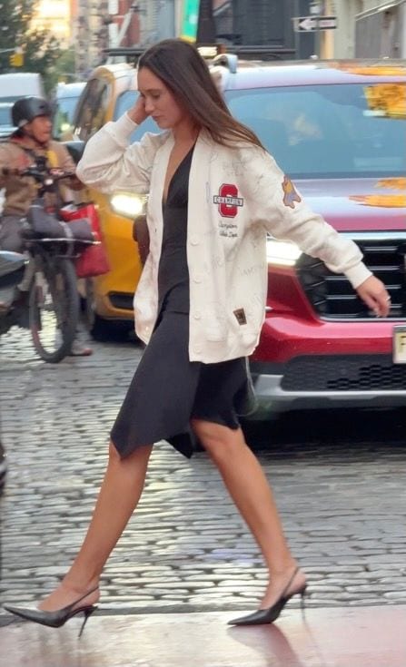 Black slip dress with an off-white graphic cardigan and black slingback heels on a city street.