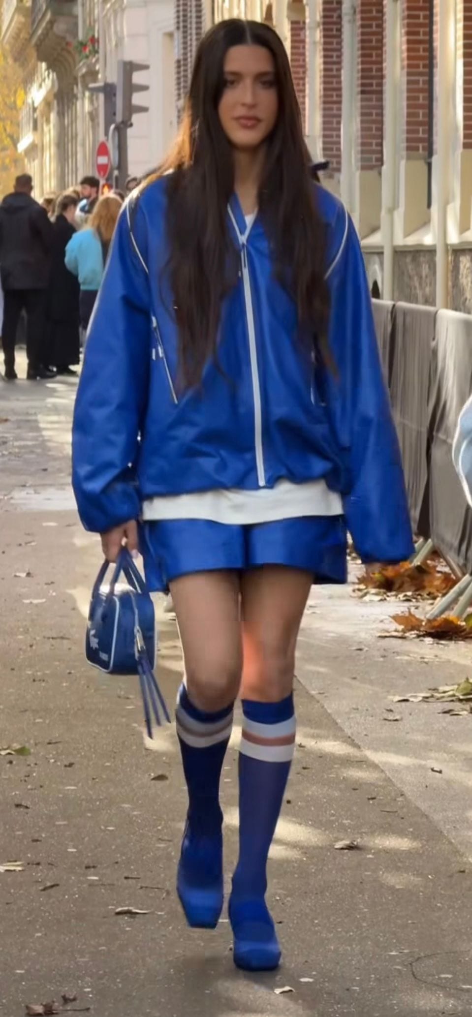 Blue oversized track jacket with matching shorts, knee-high socks, and platform shoes.