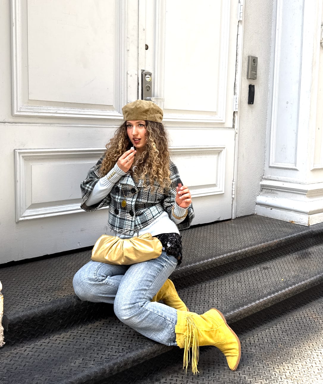 Plaid jacket, light jeans, and yellow fringed boots with a beret and gold bag.